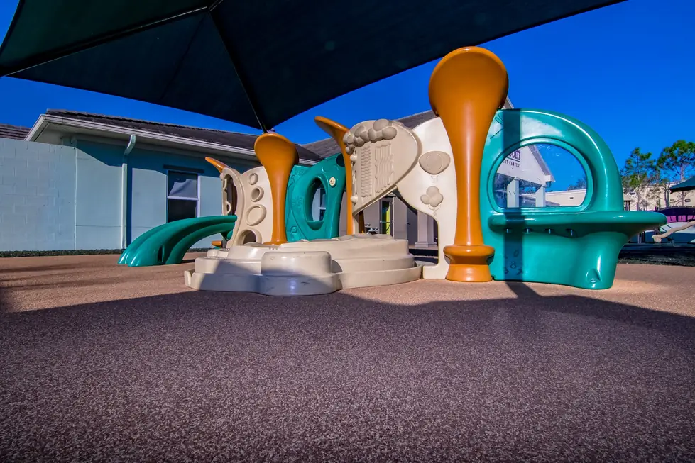 Shaded playground structure on soft rubber surfacing at Growing Room Bonita Springs