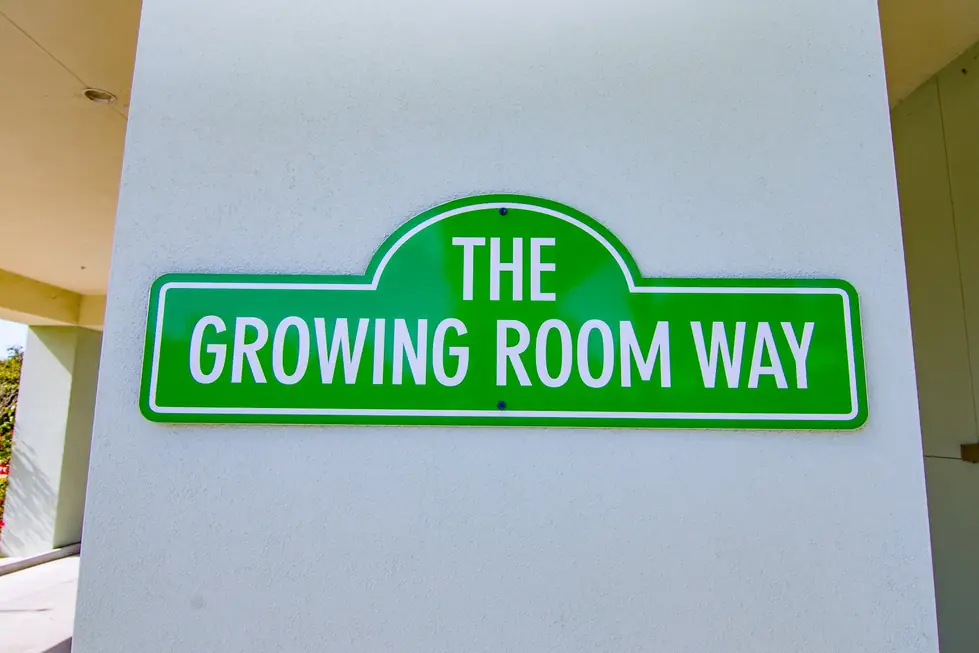 Green street-style wall sign reading The Growing Room Way